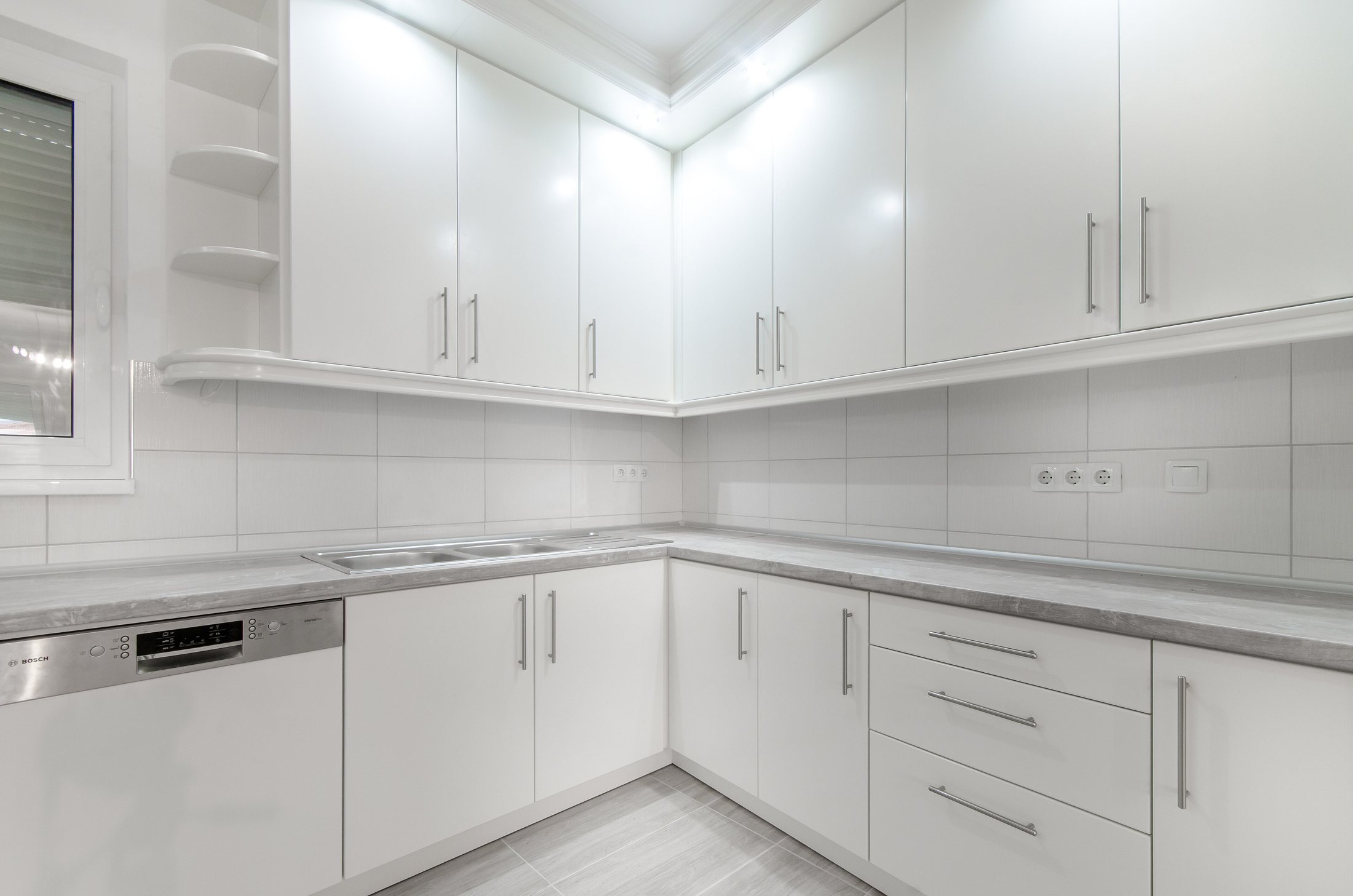 Bright white kitchen with white tile backsplash (stock photo)